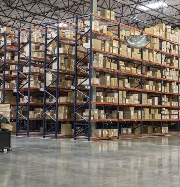 Two employees checking inventory in temporary storage in a distribution warehouse.